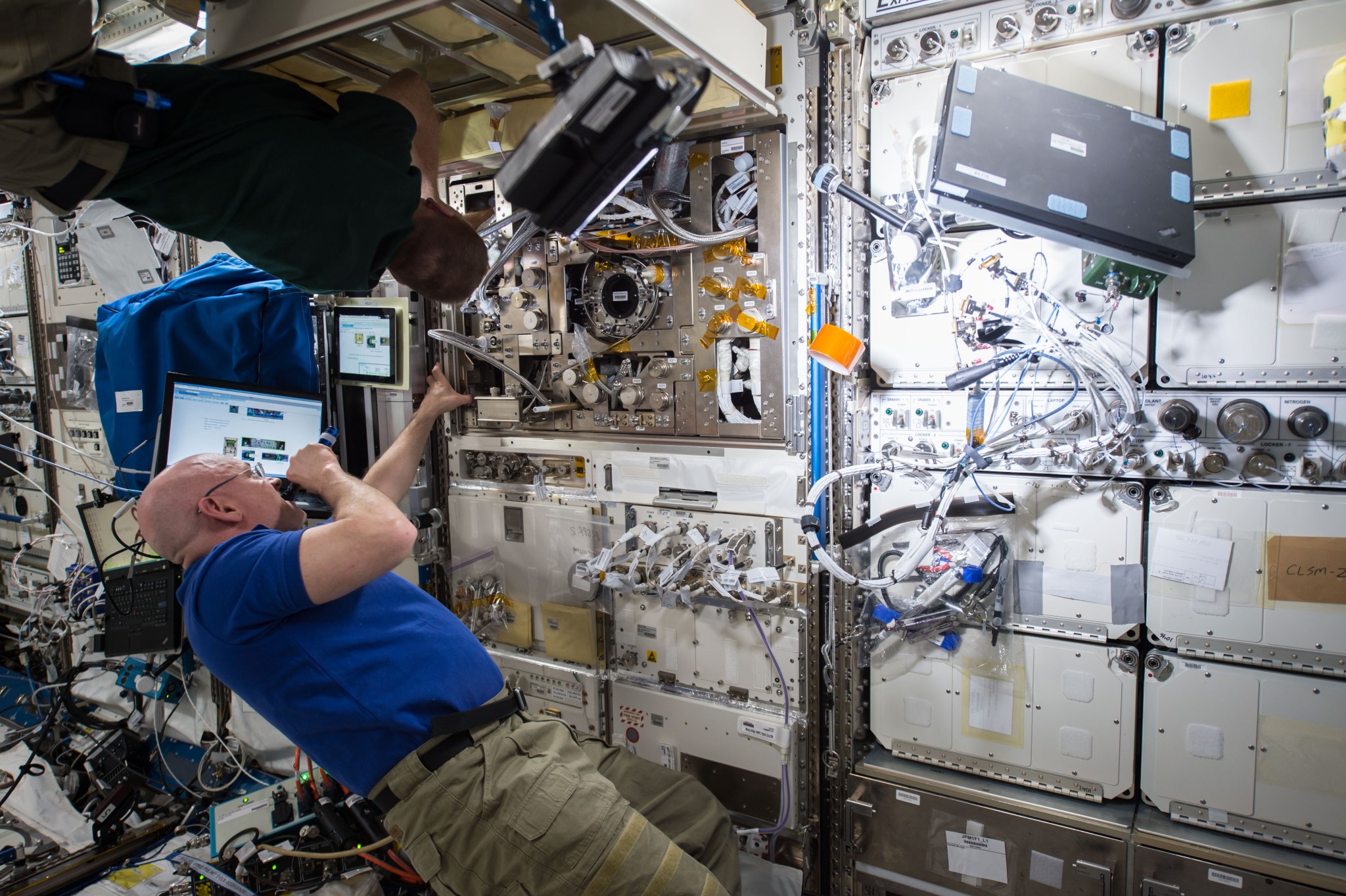 A NASA astronaut floats aboard the International Space Station while conducting an experiment.
