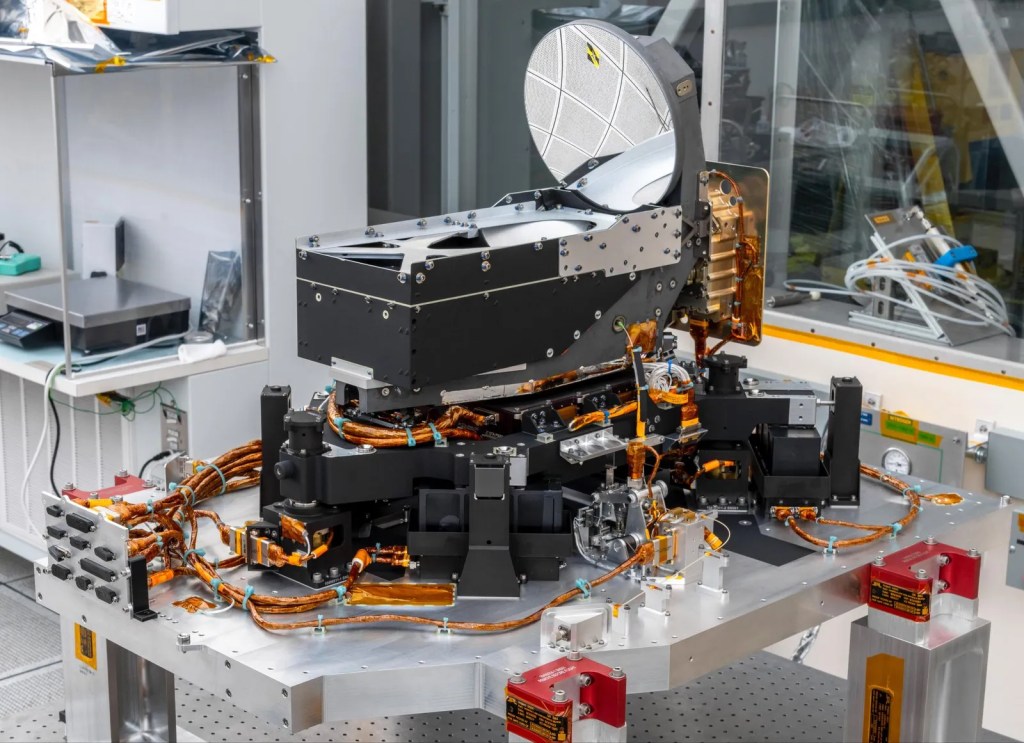 DSOC instrument on lab table, including round mirror and box mounted on struts in corners.