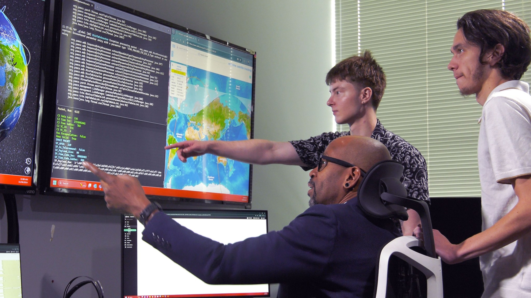 Members of the NASA Stennis Autonomous Systems Laboratory team monitor the center’s in-space satellite payload from the onsite ASTRA Payload Operation Command Center.