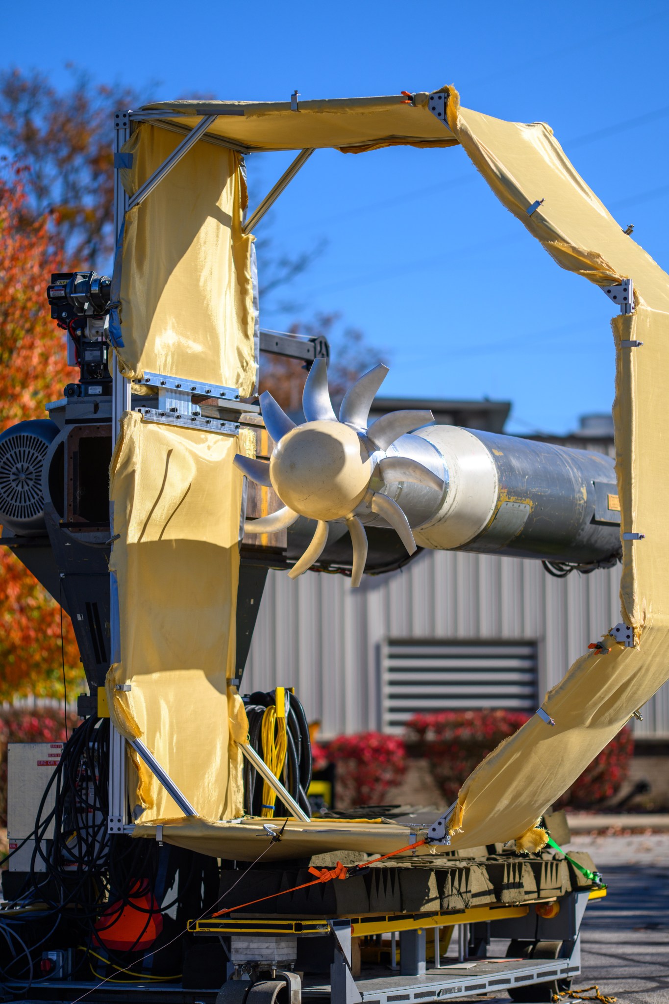 NASA’s Advanced Noise Control Fan features an open aircraft engine fan concept, which means it is uncovered. The fan is surrounded by a beige frame designed to prevent lateral winds from interfering with the test.