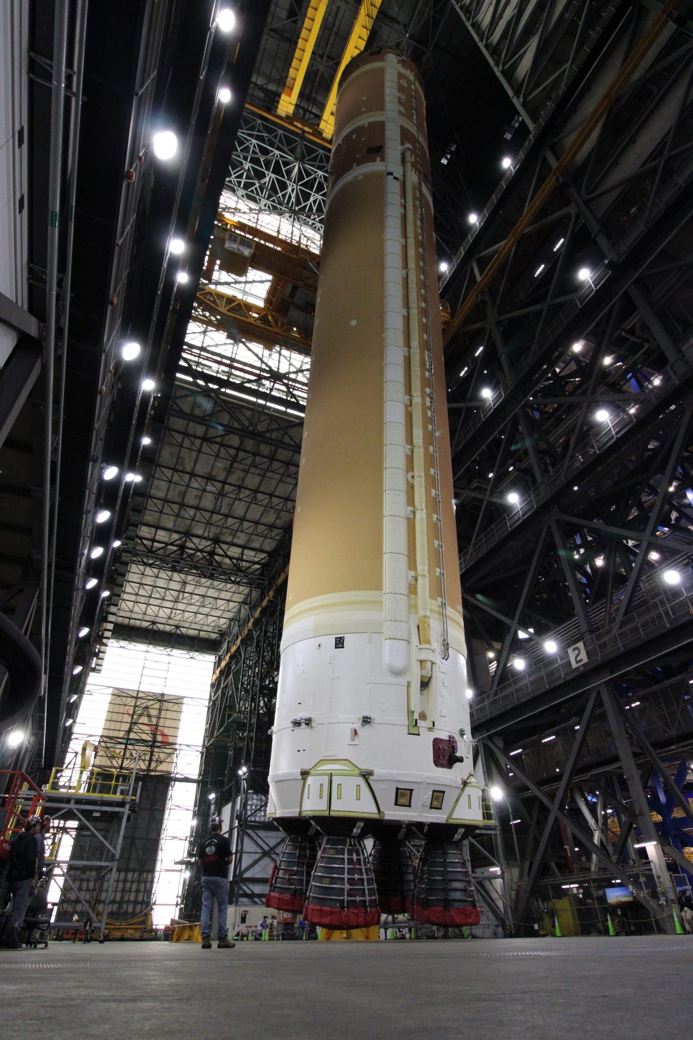 Image shows a rocket core stage move from horizontal to vertical at NASA Kennedy Space Center in Florida.