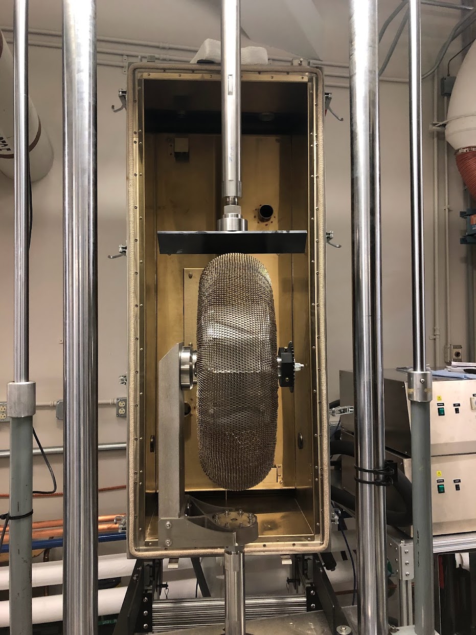 55-centimeter-diameter tire installed inside the Extreme Cyclic Environmental Load load frame and environmental chamber (front half removed for clarity) for a radial compliance test against a flat plate