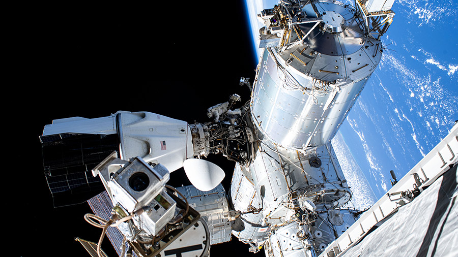 Astronaut Suni Williams (center) is dwarfed near the SpaceX Dragon crew spacecraft as she replaces advanced navigational hardware during a spacewalk on Jan. 16, 2025.
