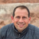 Eduardo Bendek with brown hair and a grey zip up jacket
