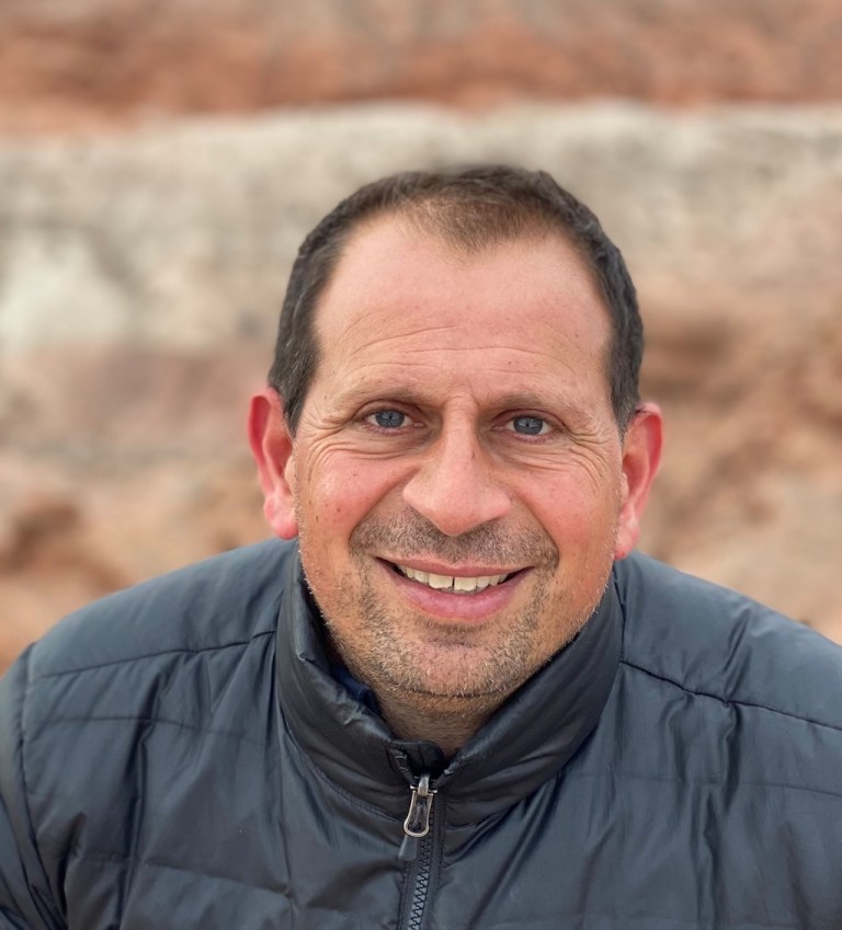 Eduardo Bendek with brown hair and a grey zip up jacket