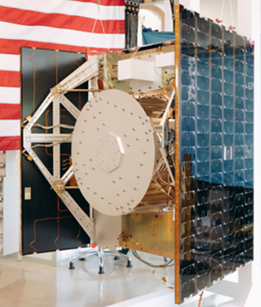 a small spacecraft with solar panels in a large room