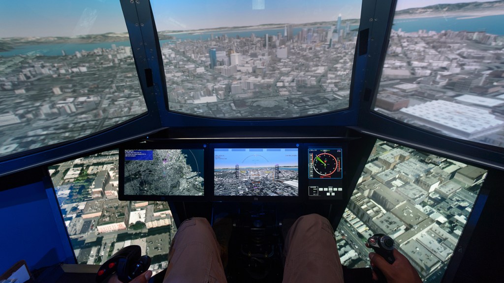 A NASA research subject sits in a flight simulator at NASA's Human Systems Integration Division's Human Autonomy Teaming (HAT) Lab during a study