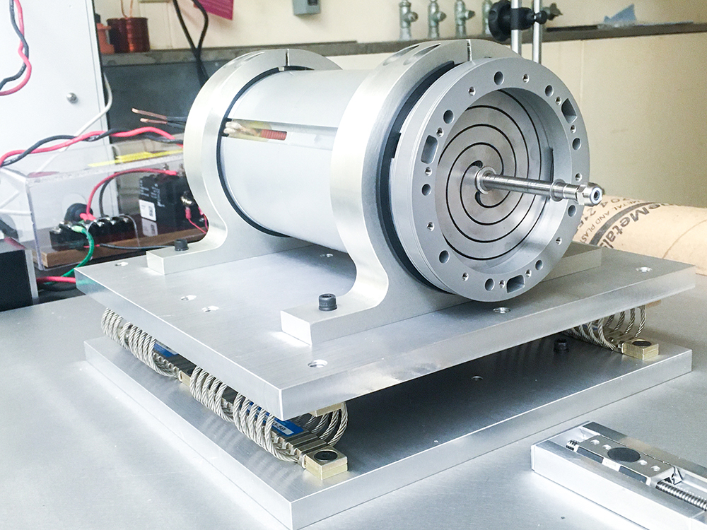 A cylinder-shaped motor with a thin rod sticking out of the center.  