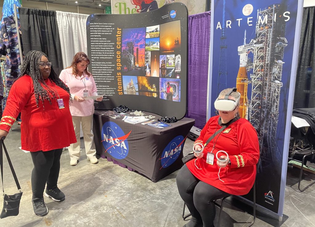 A comic con attendee experiences being on the International Space Station with the immersive virtual reality headset at the NASA booth during the 2025 FAN EXPO