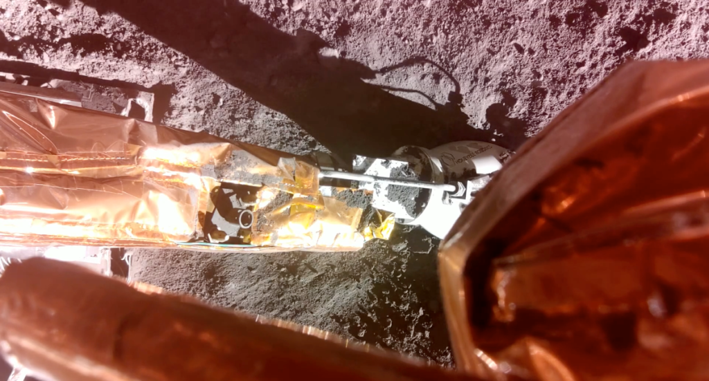 An extended leg of a spacecraft sits on the lunar surface.
