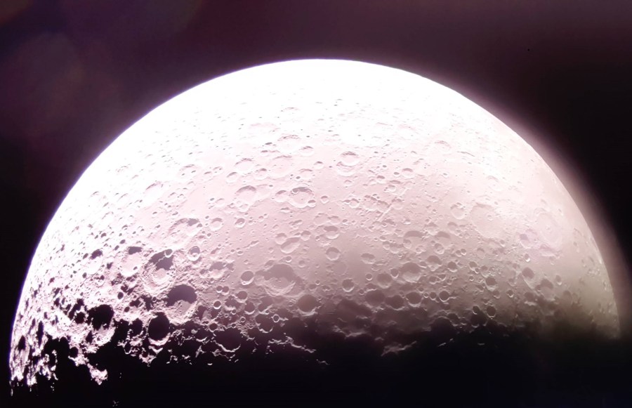A bright Moon in the darkness of space with the Moonâs South Pole visible on the far left.