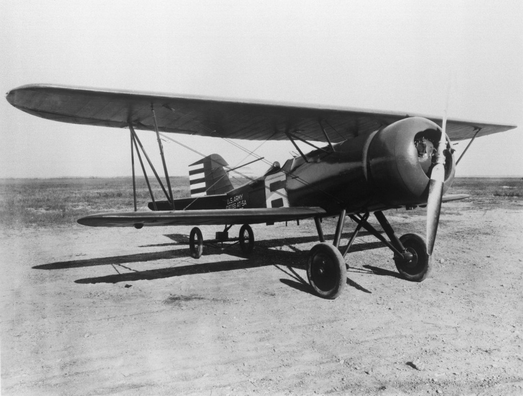 A biplane with a single propeller from 1928 sits on the ground.