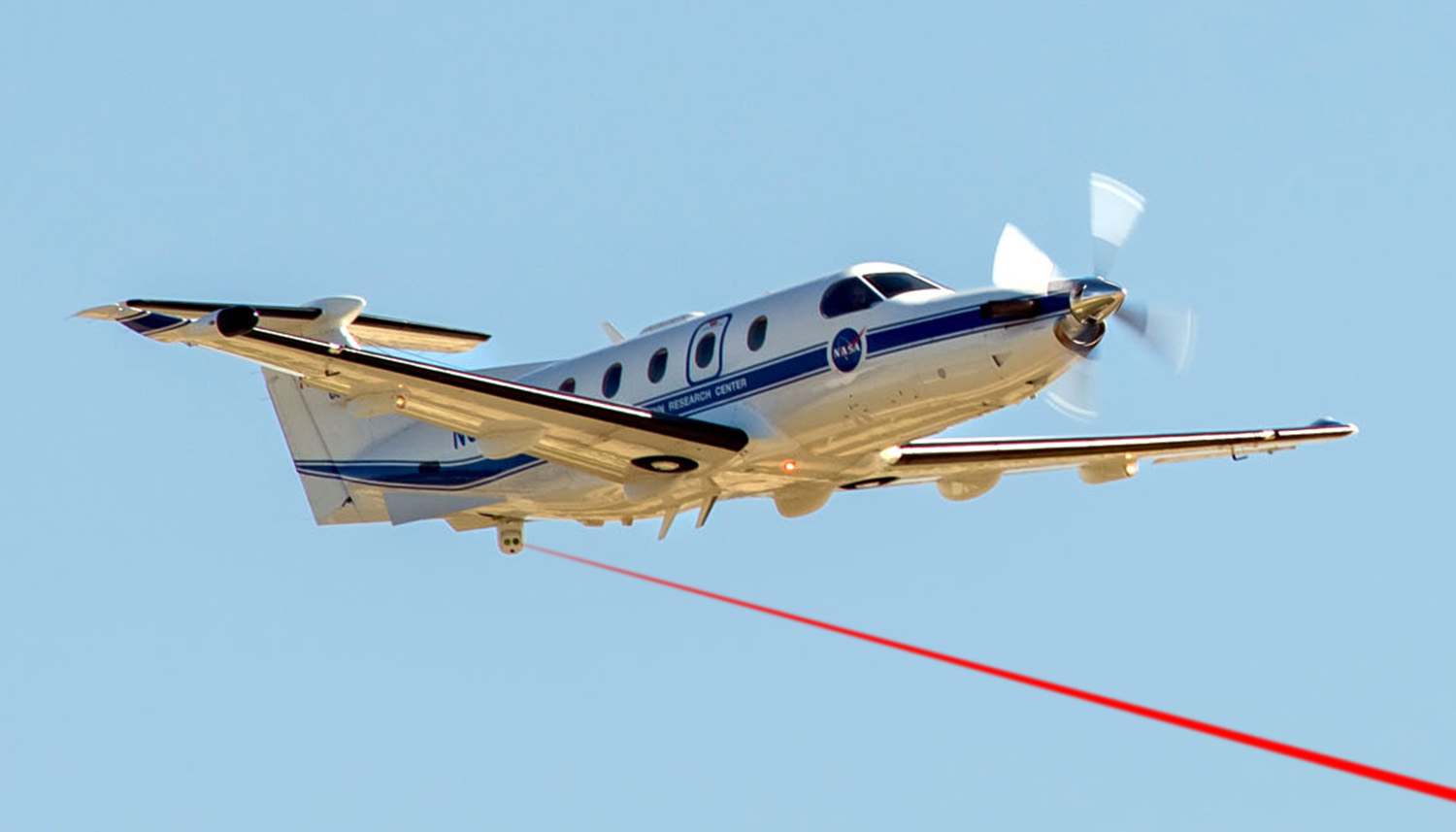Airborne photo of PC-12 and Airborne Laser Communication Testbed mounted in the tail cone with simulated laser beam.