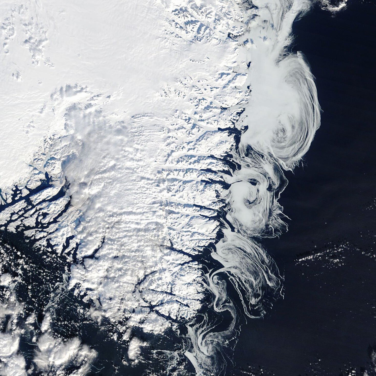 Greenland is an icy place year-round, but the winter months bring extra whorls of white. This satellite image, captured on February 24, 2025, shows the southern part of the island, from its snow-topped ice sheet and glaciers to the sea ice swirling along its coasts. The image was acquired by the MODIS (Moderate Resolution Imaging Spectroradiometer) on NASA’s Terra satellite.