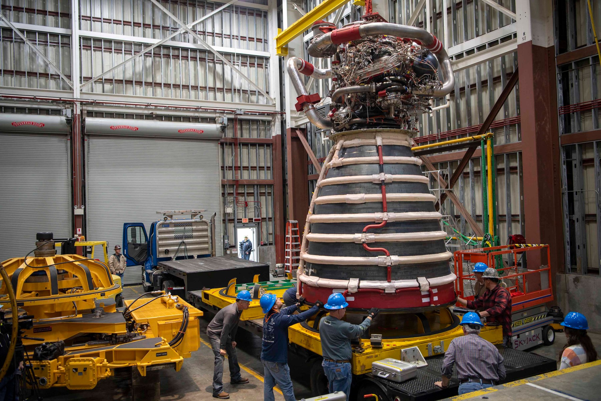 crew members work to prep the new production RS-25 for delivery to NASA Stennis