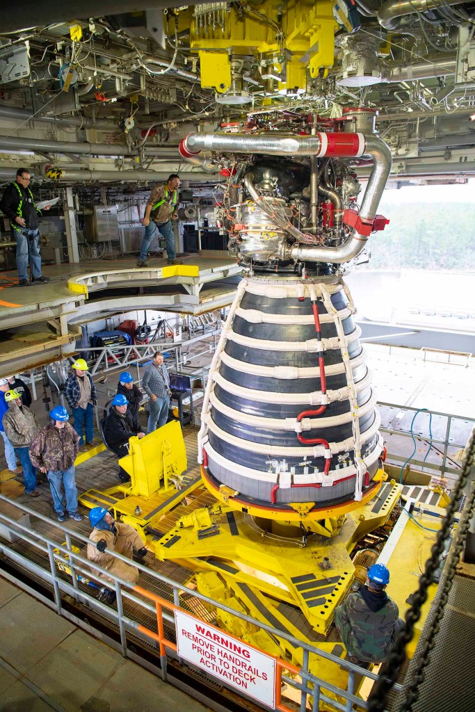 crew installing the first new production RS-25 engine on the Fred Haise Test Stand