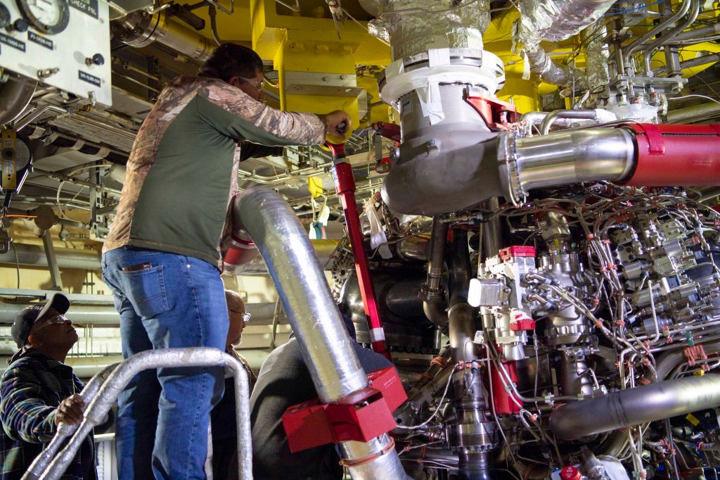 crew installing the first new production RS-25 engine on the Fred Haise Test Stand