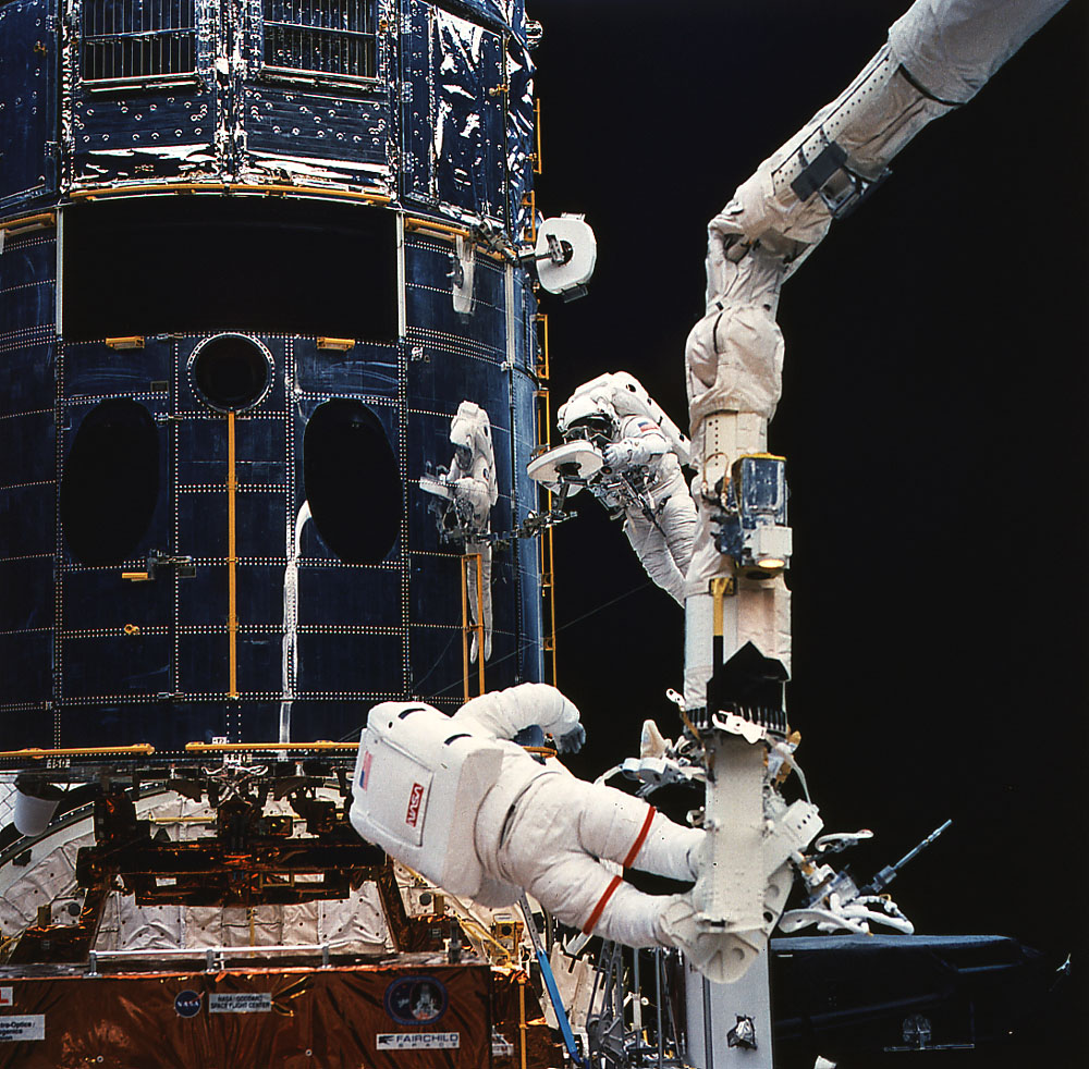 Anchored on the end of orbiter Endeavour's remote manipulator system arm, astronaut Jeffrey Hoffman prepares to install the new camera into the Hubble Space Telescope