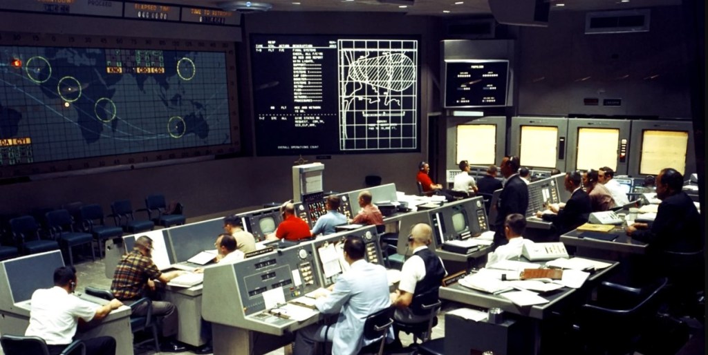 Somewhat dark image of a mission control center.