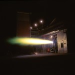 Rocket engine firing horizontally at night.