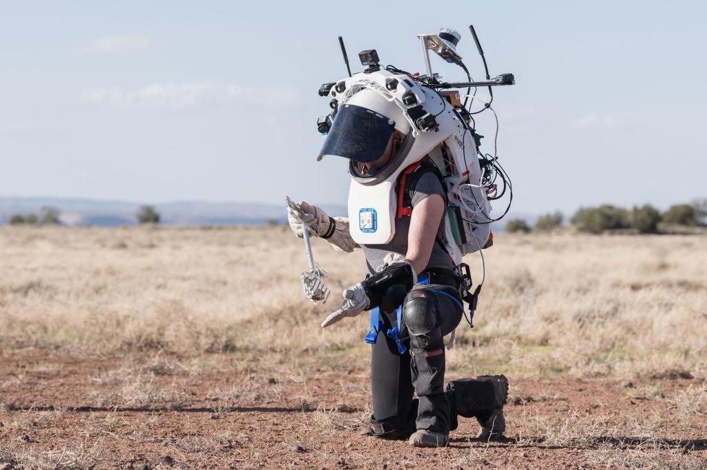 NASA astronaut Kate Rubins uses tongs to pick up a geologic sample while wearing the Joint AR (Joint Augmented Reality Visual Informatics System) display during an advanced technology run