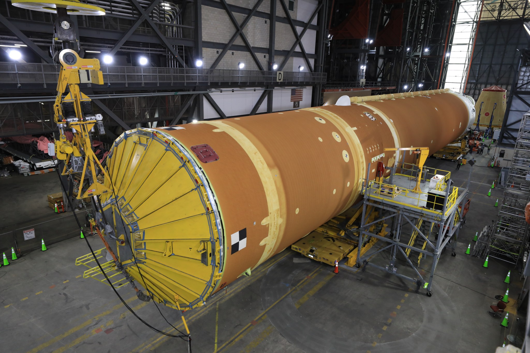 Technicians from NASA’s Exploration Ground Systems use massive cranes inside the agency’s Vehicle Assembly Building (VAB) to lift the fully assembled SLS (Space Launch System) core stage vertically 225 feet above the ground from High Bay 2 to a horizontal position in the facility’s transfer aisle at NASA’s Kennedy Space Center in Florida on Friday, March 14, 2025. The 212-foot core stage will undergo final checkouts before being lifted into the VAB’s High Bay 3 for integration alongside the completed stack of twin solid rocket booster segments.