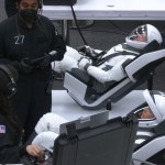 Image shows astronauts suiting up in spacesuits.