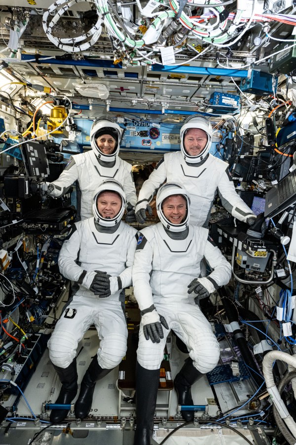 Image shows astronaut in their suits inside the International Space Station