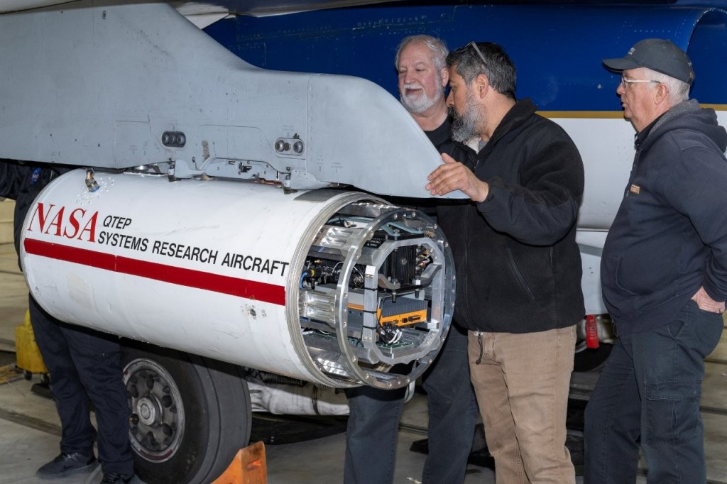 3 men install the PSNDL system onto an aircraft.