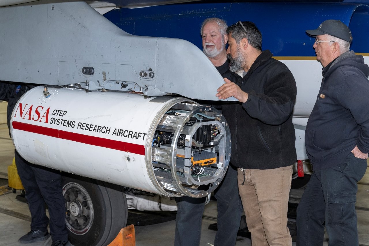 3 men install the PSNDL system onto an aircraft.