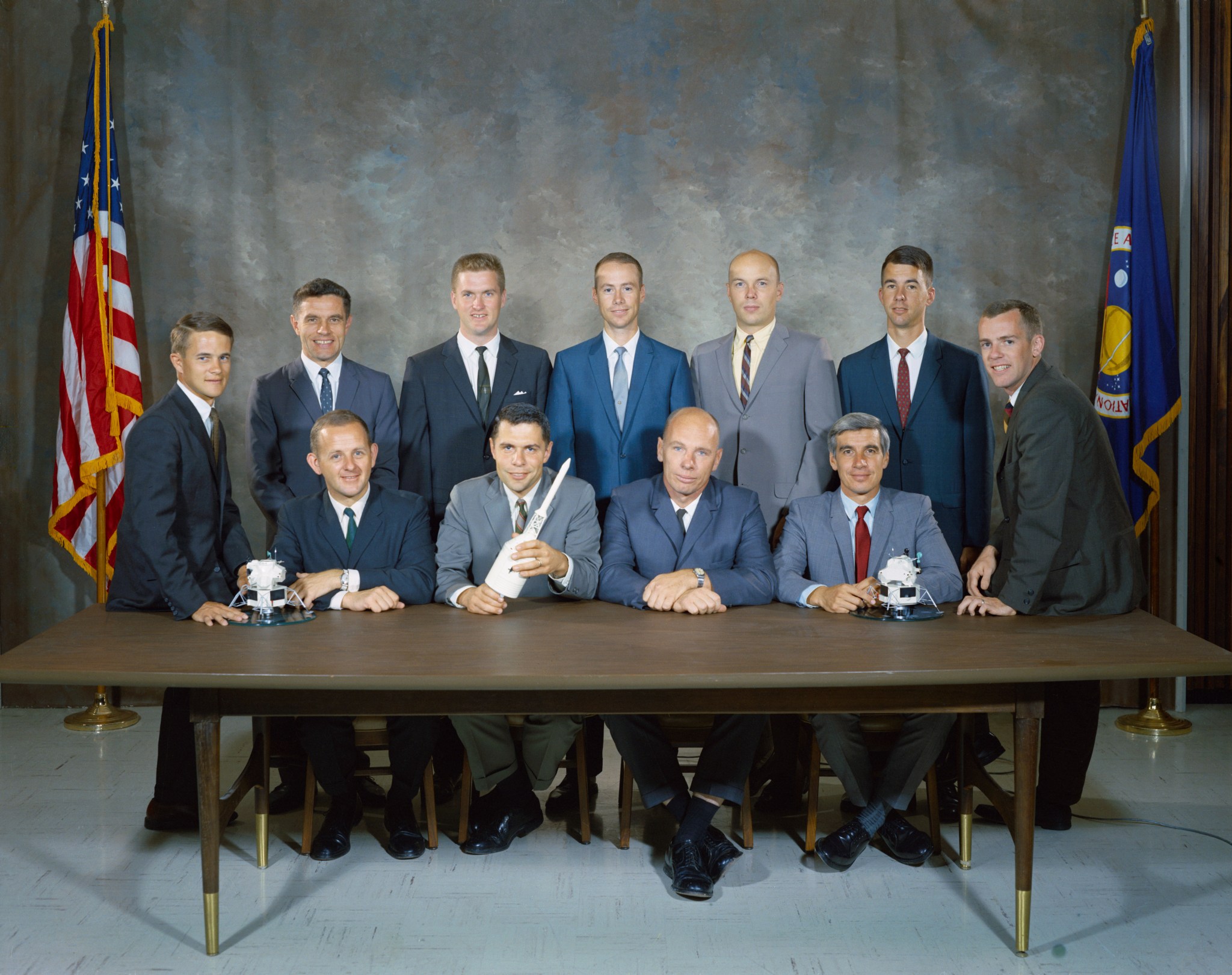 Portrait of NASA's 1967 class of astronauts at a table
