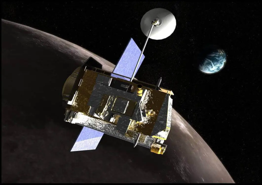 An artist’s concept of a spacecraft traveling through space. Its rectangular body is made up of various instruments, many of which are covered in shiny silver and gold foil. Two light-blue solar panels extend on either side of its body. A white satellite dish is mounted on top of the spacecraft, aimed towards a distant blue planet with white clouds. A nearby gray-brown planet takes up the majority of background, framed by the black of space. Both planets are partially covered in shadows.