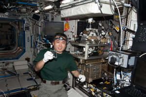 JAXA astronaut Koichi Wakata holds an Advanced Colloids Experiment (ACE)-M-1 sample.