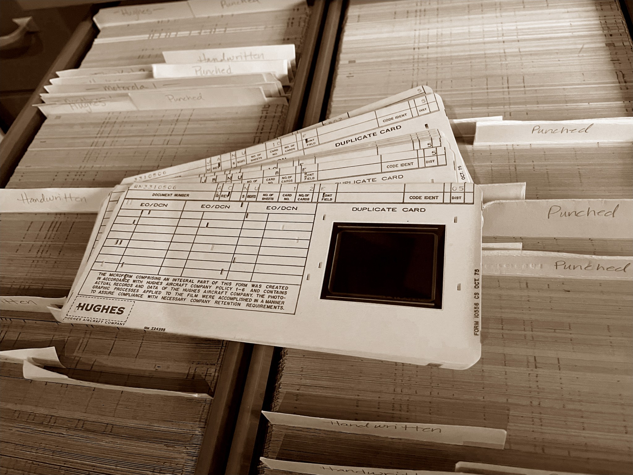 A few aperture cards sit atop a collection of hundreds of cards.