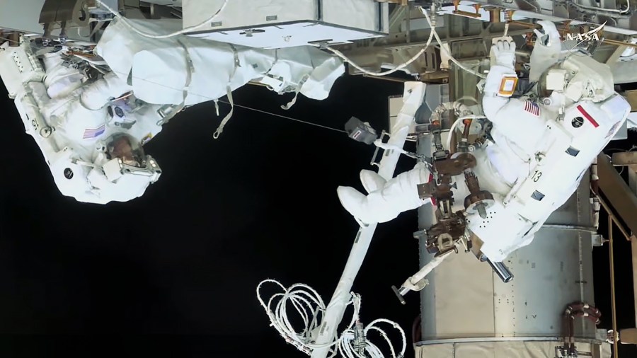 NASA spacewalkers (from left) Nichole Ayers and Anne McClain work together at the International Space Station's Port-4 truss structure to install a modification kit readying the orbital outpost for a future rollout solar array.