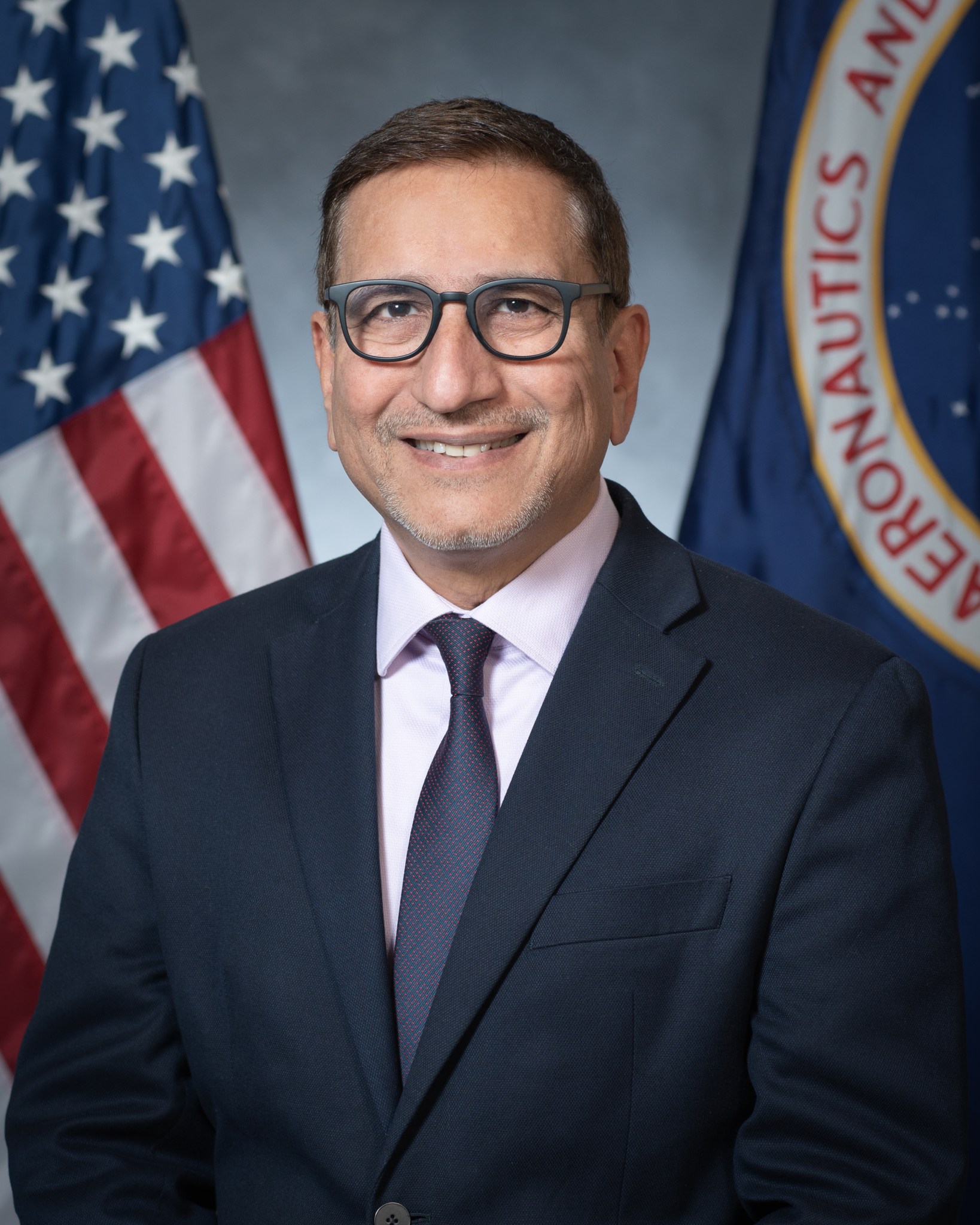 Portrait of Shahab Chaudhry with American flag behind him.