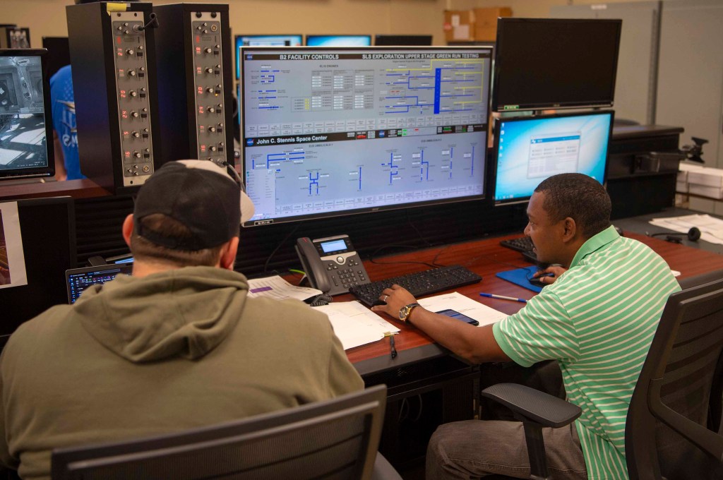 NASA engineers Chad Tournillon, left, and Robert Smith verify the functionality of a control system