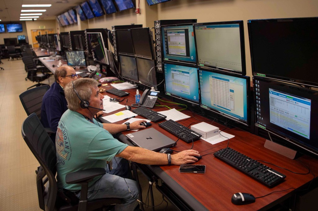 two NASA engineers seated at workstation monitoring data during the activation of the interstage simulator gas systems