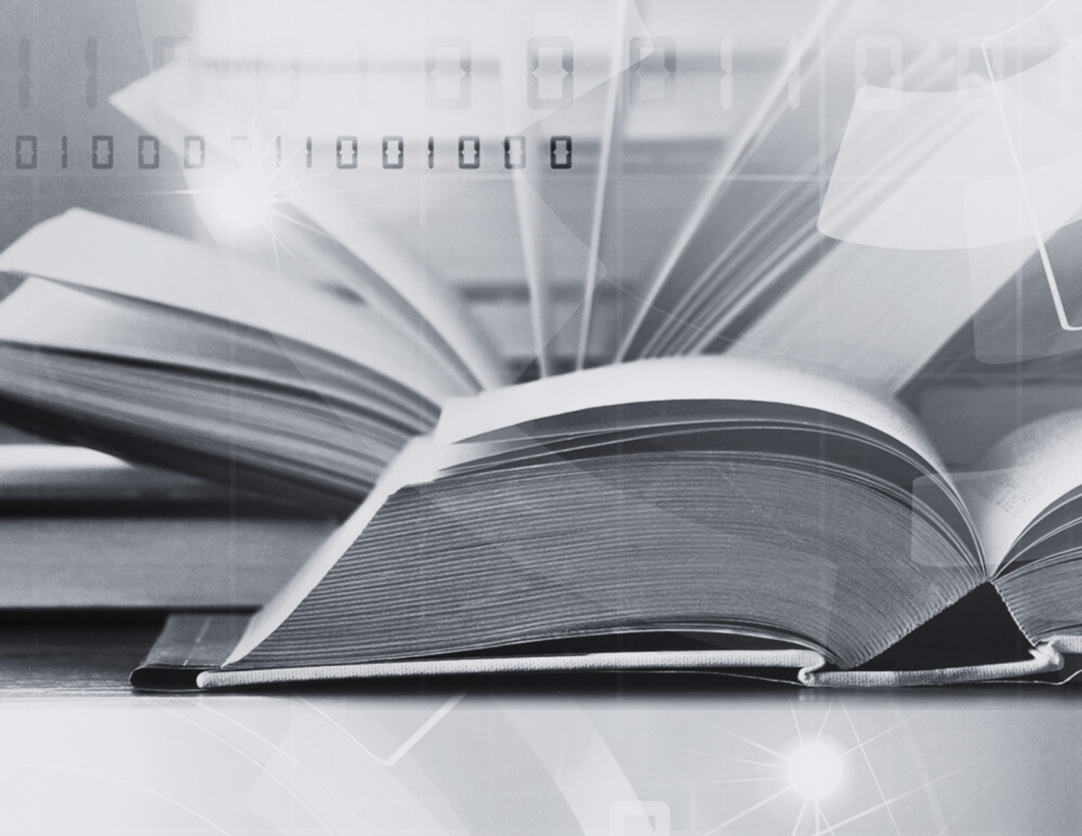 A black and white image of a close-up shot of a book laying open on a table.