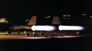 Aircraft on ground firing afterburners at night.