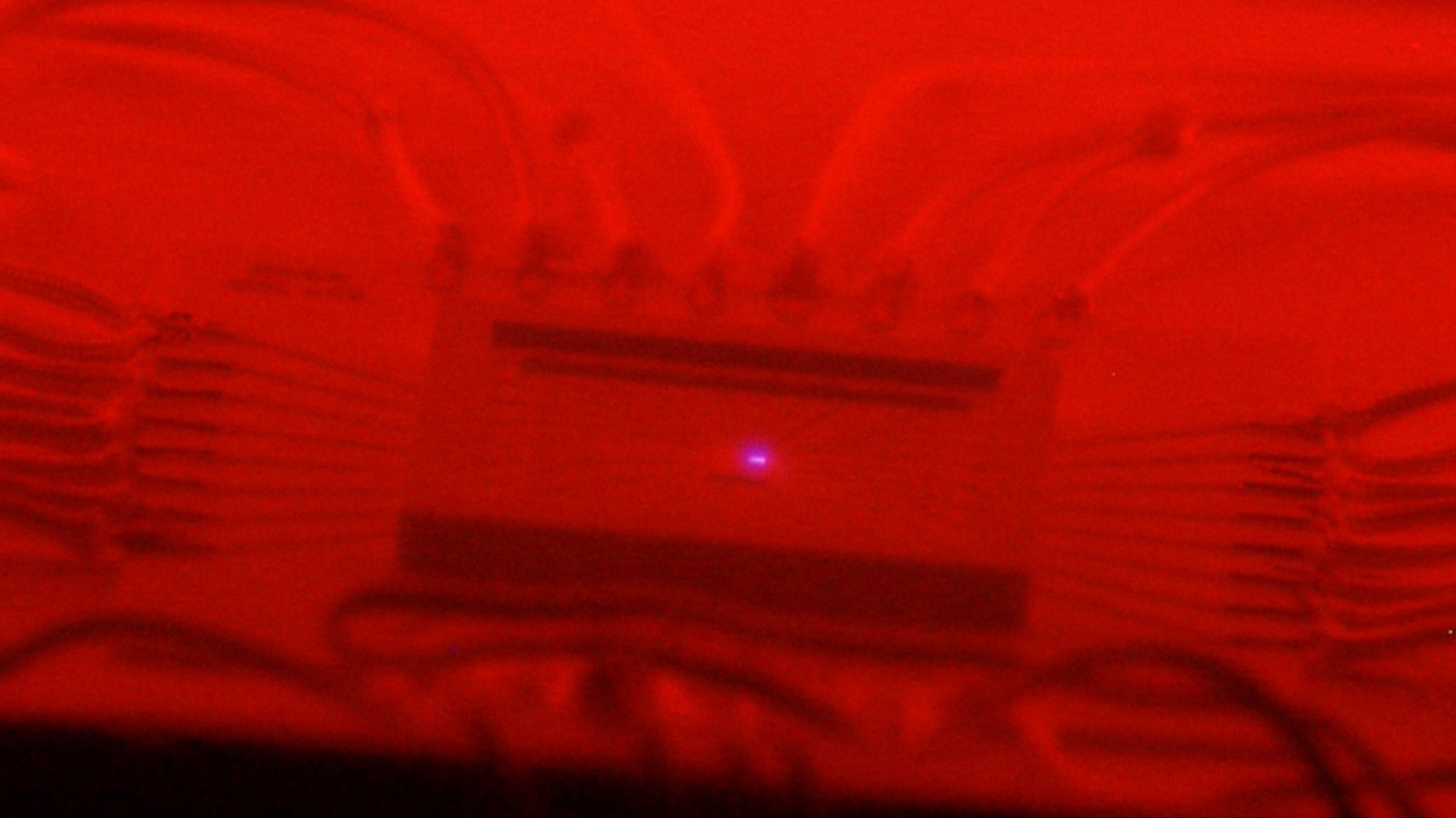 Glowing red-hot SiC chip centered in ceramic packaging emits blue light under glowing red hot high-temperature operation.