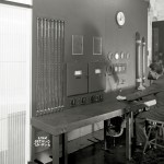 Man in suit sitting in control room.