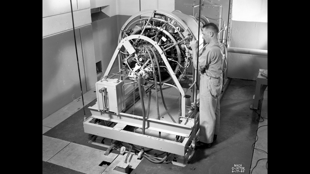Mechanic working on engine in test cell.