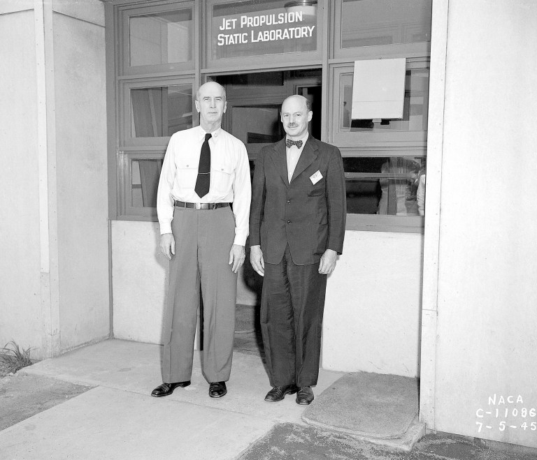 Two men in front of doorway.
