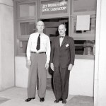 Two men standing outside doorway.