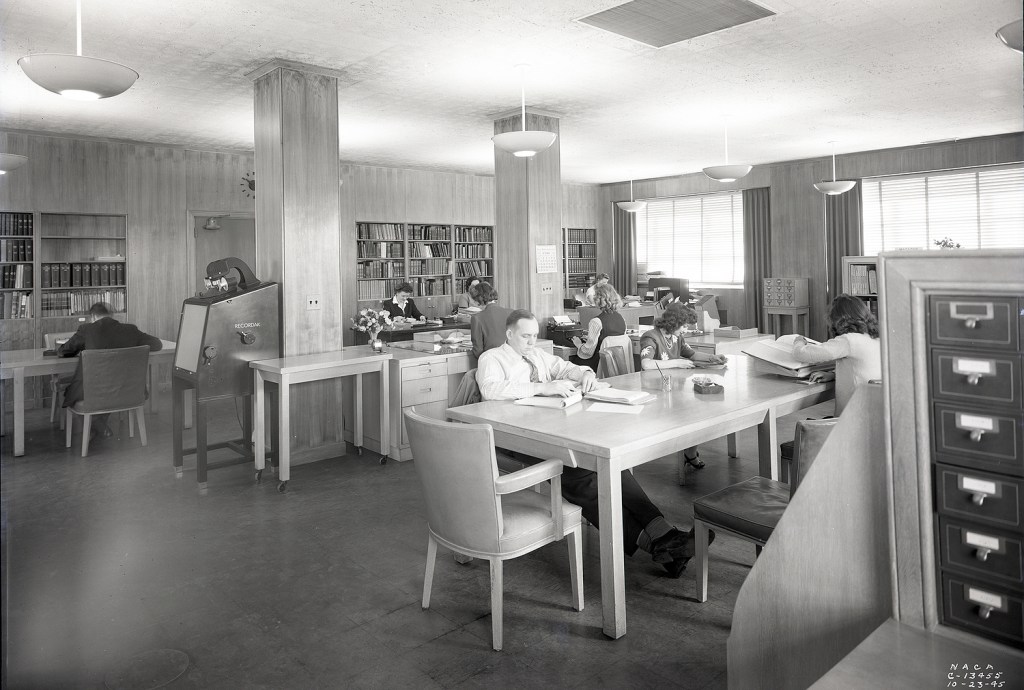 People sitting at tables in library.