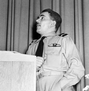 Man in military uniform at podium.