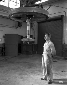 Mechanic watches spin equipment suspended from crane.