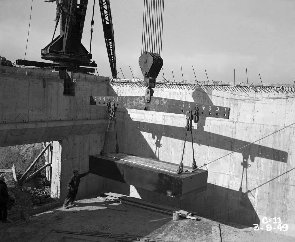 Crane lowering yoke into pit.