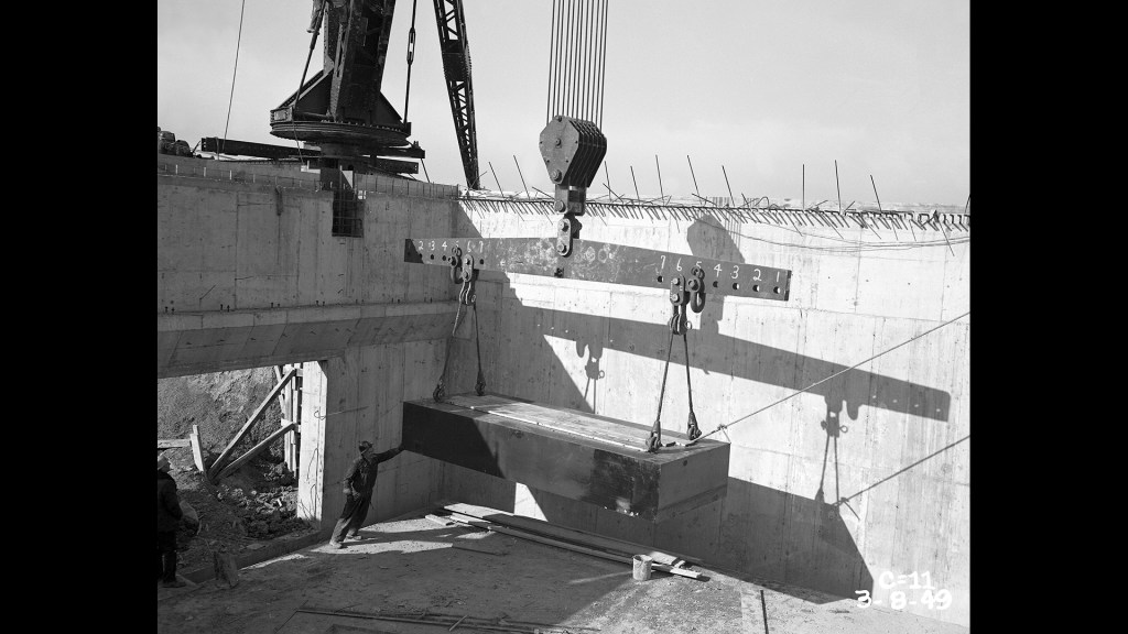 Crane lowering yoke into pit.